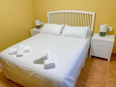 a bedroom with a white bed with towels on it at Roca de Guía Somiedo in Pola de Somiedo