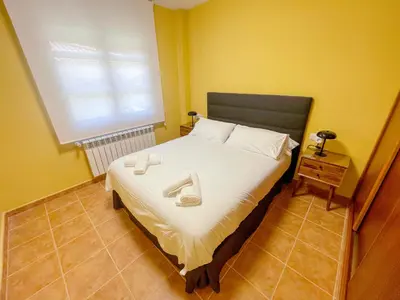 a bedroom with a bed with two towels on it at Roca de Guía Somiedo in Pola de Somiedo