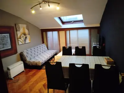 a living room with a table and a couch at Ático Milladoiro in Milladoiro