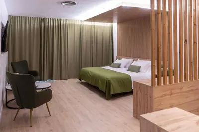 a bedroom with a bed and a chair in a room at Hotel & Restaurante El Casino in Villafranca del Bierzo