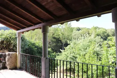 a porch with a fence and trees in the background at Luxury Pombar in Ourense