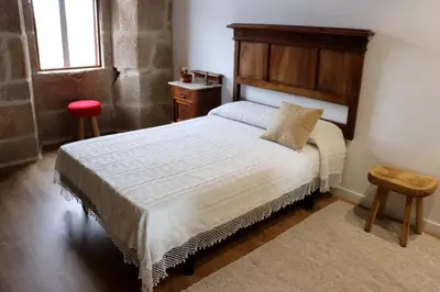 a bedroom with a large bed and a red stool at Luxury Pombar in Ourense