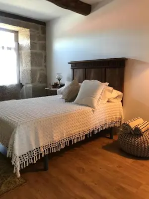 a bedroom with a bed with a wooden headboard at Luxury Pombar in Ourense
