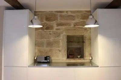 a kitchen with two lights and a stone wall at Luxury Pombar in Ourense