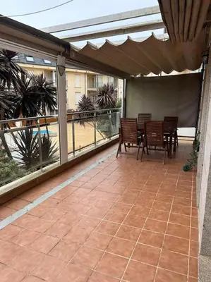 a patio with a table and chairs on a balcony at Piso cerca de la playa, dos habitaciones, piscina y terraza in San Ciprián