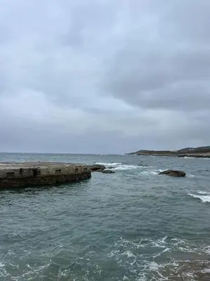 a body of water with rocks in the ocean at Piso cerca de la playa, dos habitaciones, piscina y terraza in San Ciprián