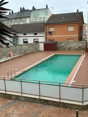 a large swimming pool in the middle of a house at Piso cerca de la playa, dos habitaciones, piscina y terraza in San Ciprián