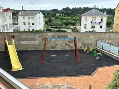 a playground with play equipment on a roof at Piso cerca de la playa, dos habitaciones, piscina y terraza in San Ciprián