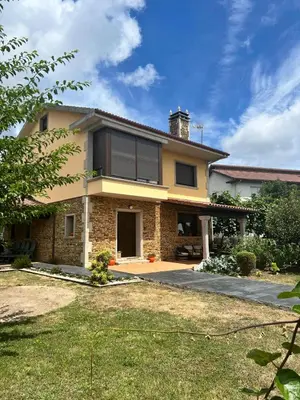 a large brick house with a large window at Vivienda turistica Os Galegos en Palas de Rey in Palas de Rei