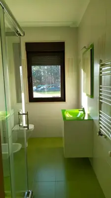 a bathroom with a green sink and a window at Vivienda turistica Os Galegos en Palas de Rey in Palas de Rei