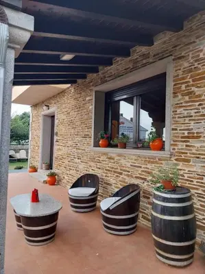 a patio with chairs and a table and a brick wall at Vivienda turistica Os Galegos en Palas de Rey in Palas de Rei