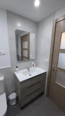 a bathroom with a sink and a toilet and a mirror at Alojamiento Las Nogueiras in La Caridad