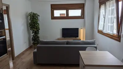 a living room with a couch and a tv at Alojamiento Las Nogueiras in La Caridad