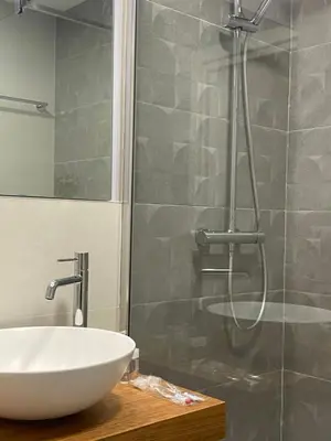 a bathroom with a white sink and a shower at Apartamentos Buenos Aires,en el centro de Ribadeo con vistas a la ría in Ribadeo