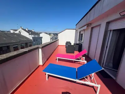 a balcony with two tables and pink chairs on it at Ático Calvo Sotelo 217 in Sarria