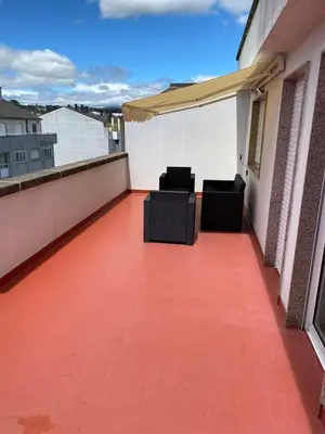 a balcony with two chairs on a roof at Ático Calvo Sotelo 217 in Sarria