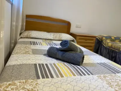 a bed with two twin beds with towels on it at Ático Calvo Sotelo 217 in Sarria