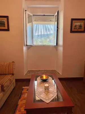 a bed with a table with a lamp on it at Apartamento Amanecer in Baltar