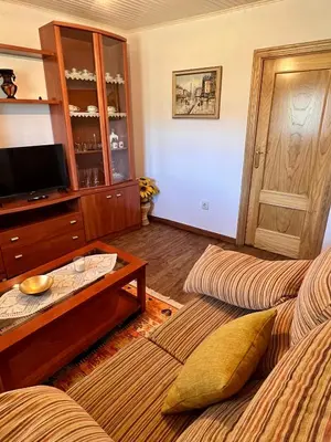 a living room with a coffee table and a tv at Apartamento Amanecer in Baltar