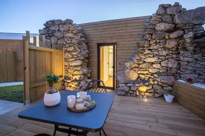 a blue table on a deck with a stone wall at as Alvarizas in Moraña