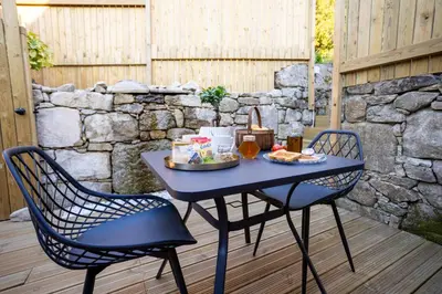 a table with a tray of food and two chairs at as Alvarizas in Moraña