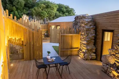a patio with a table and chairs on a wooden deck at as Alvarizas in Moraña