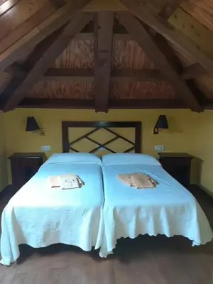a bedroom with two beds with white sheets at Casa del OSO2 in Pola de Somiedo
