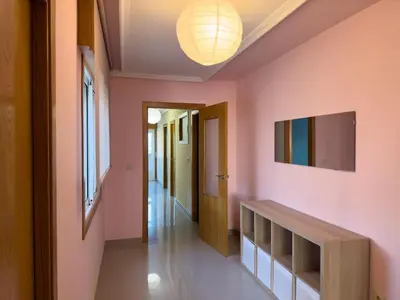 a hallway with pink walls and a television on the wall at O Nido de Noe in Melide