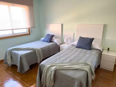 a bedroom with two beds and a window at O Nido de Noe in Melide