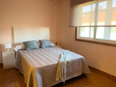 a bedroom with a bed with blue pillows and a window at O Nido de Noe in Melide