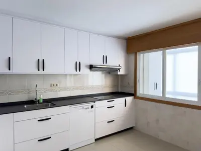 a kitchen with white cabinets and a window at O Nido de Noe in Melide