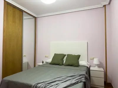 a bedroom with a bed with two green pillows at O Nido de Noe in Melide
