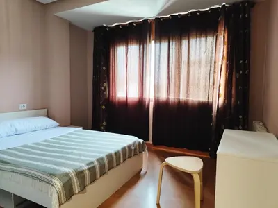 a bedroom with a bed and a chair and a window at Piso de Alba in Chantada
