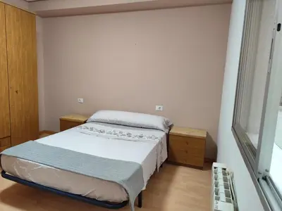 a small bedroom with a bed and a window at Piso de Alba in Chantada
