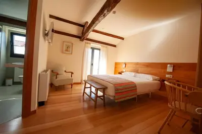 a bedroom with a bed and a desk and a chair at Casa do Cereiro in A Estrada