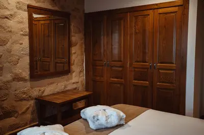 a bedroom with a bed and wooden cabinets at Pazo Arretén in Padrón