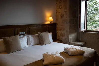 a bedroom with a large bed with towels on it at Pazo Arretén in Padrón