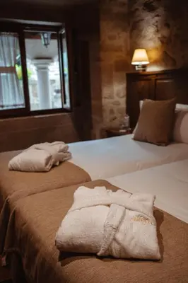 a hotel room with two beds with towels on them at Pazo Arretén in Padrón