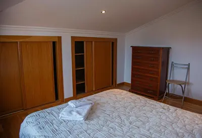 a bedroom with a bed and a dresser and a chair at Mirador del Camino in Melide