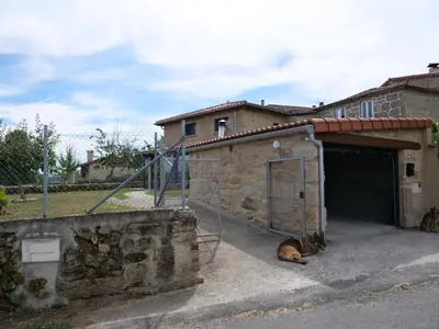 a dog laying on the ground in front of a garage at Casa Mateo in Allariz