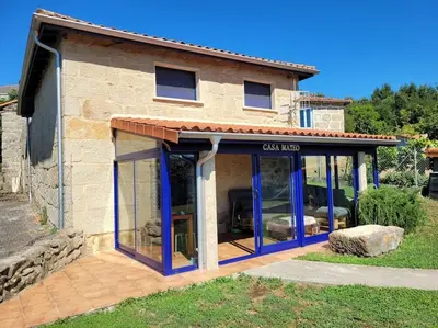 a house with a garage with blue glass doors at Casa Mateo in Allariz