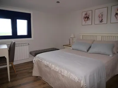 a bedroom with a bed and a desk and a window at Casa Mateo in Allariz