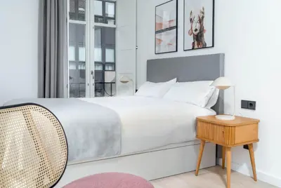 a white bedroom with a bed and a table at Limehome Santiago de Compostela in Santiago de Compostela