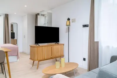 a living room with a flat screen tv on a cabinet at Limehome Santiago de Compostela in Santiago de Compostela