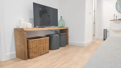 a living room with a tv and two trash cans at Apartamento La Ribera in Betanzos