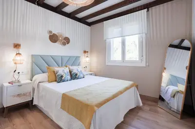 a bedroom with a large bed and a mirror at Apartamentos Bágoas de Mencía Peares Ribeira Sacra in Carballedo