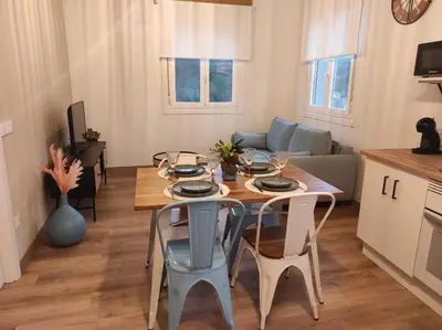 a dining table and chairs in a living room at Apartamentos Bágoas de Mencía Peares Ribeira Sacra in Carballedo