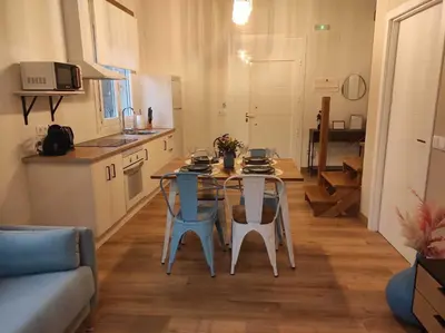 a kitchen and a table and chairs in a living room at Apartamentos Bágoas de Mencía Peares Ribeira Sacra in Carballedo