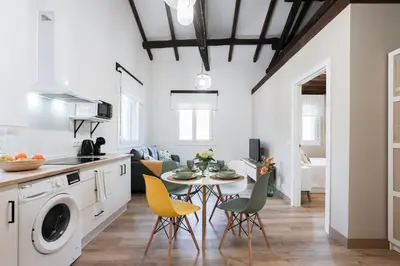 a kitchen and living room with a table and chairs at Apartamentos Bágoas de Mencía Peares Ribeira Sacra in Carballedo