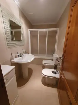 a bathroom with a white toilet and a sink at Casa en zona rural in Cervo